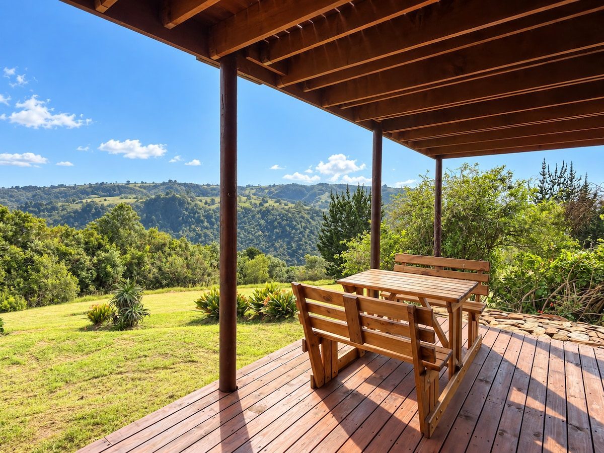 Covered terrace with a timber table looking over the forest
