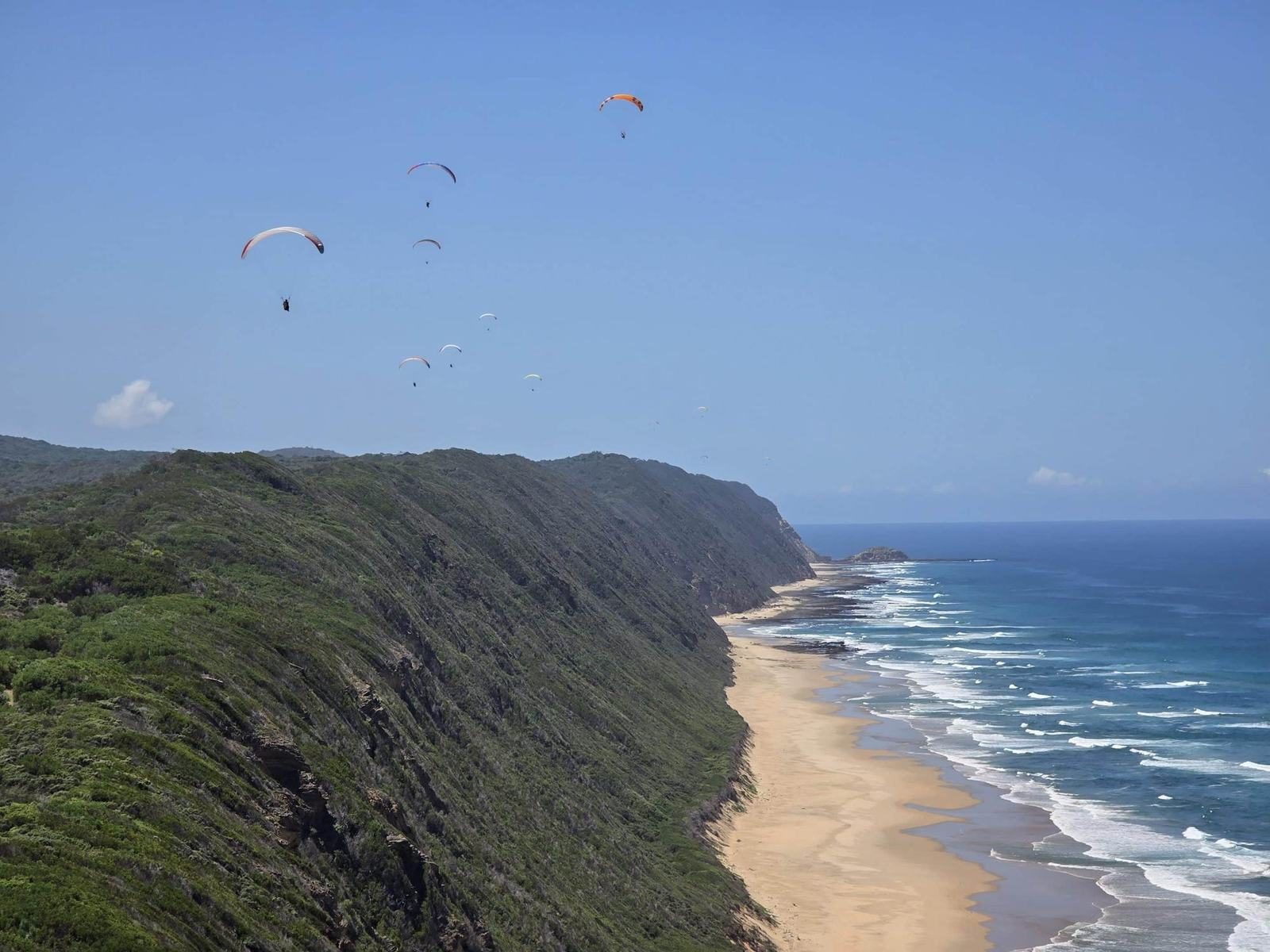 Paragliders soaring the ridge between the Map of Africa and Wilderness Beach